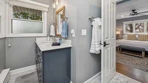 A modern bathroom with a vanity, a large mirror, and a window. - Nautical, Pet-Friendly | Walk to Lake & Downtown (Lake Geneva)