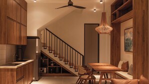 Une cuisine moderne avec des meubles en bois, une cuisinière encastrée et un coin repas comprenant une table et des chaises en bois.
