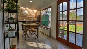A modern kitchen with a wooden countertop, a dining table, and a large window with a view of the outdoors.