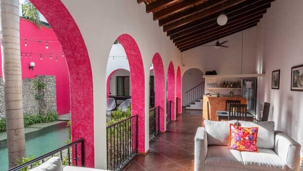 A spacious outdoor area with a covered patio, white sofas, and a pool. - Los Suspiros Hotel Boutique & Spa (Comala)