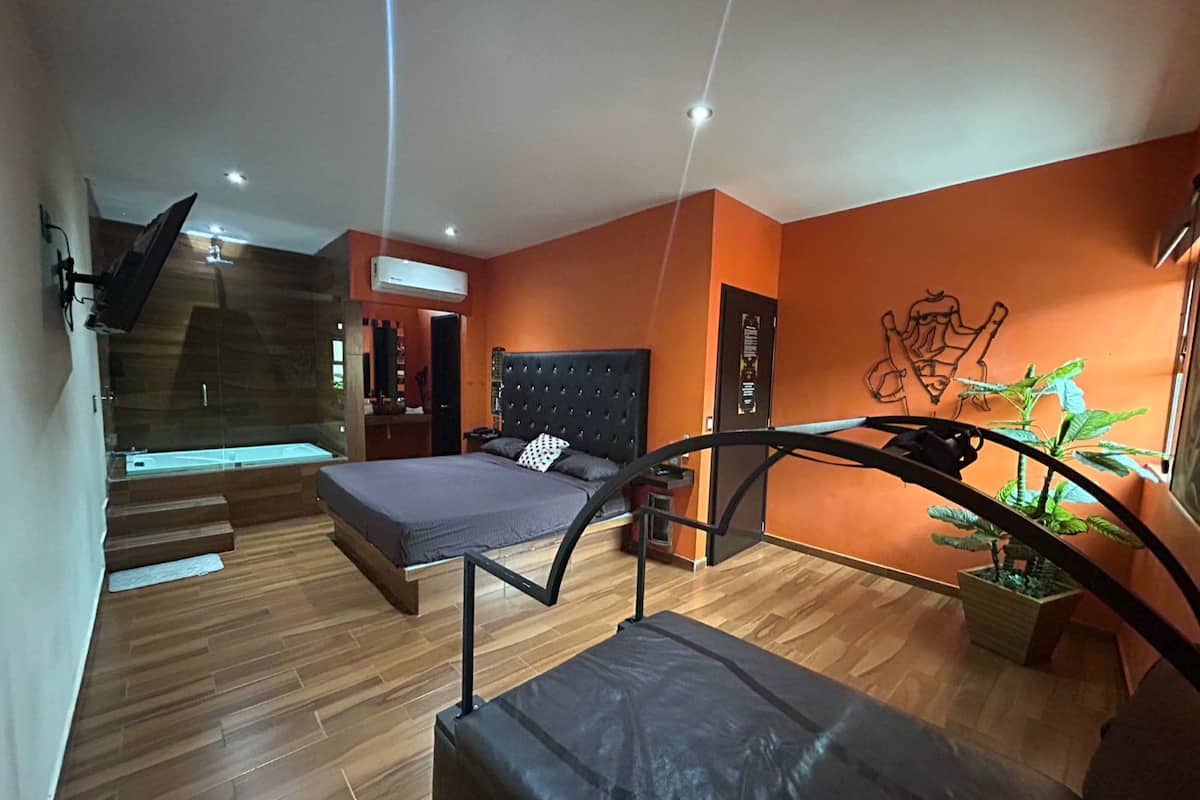 Ein modernes Schlafzimmer mit einem Bett, einer Treppe und einer Topfpflanze.