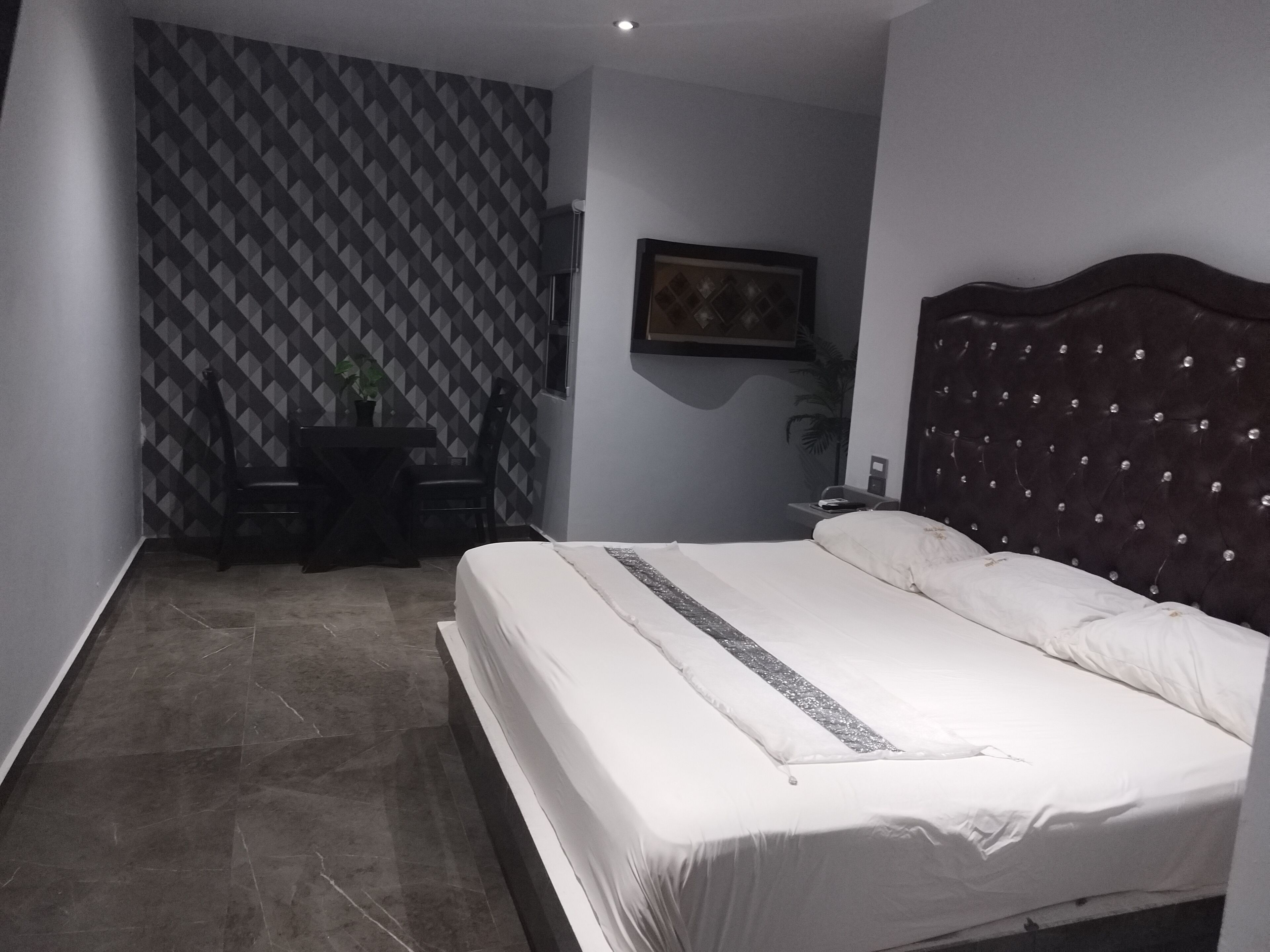 Quarto com uma cama, uma escrivaninha e uma cadeira.