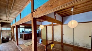 A traditional Japanese-style room with tatami flooring, wooden beams, and sliding doors.
