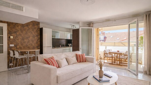 Una sala de estar moderna con sofá, mesa de centro y comedor.