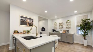 A modern kitchen with a central island, built-in appliances, and a view of the cityscape.