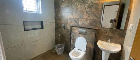 A bathroom with a toilet, sink, and shower.