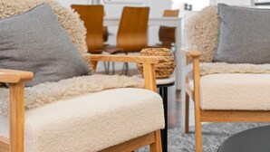 A cozy living room with two plush sofas, each with a wooden armrest and a fluffy white cushion. - Spacious 3-Bed House in Leafy Paddington (Paddington)