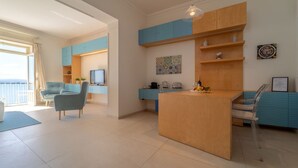 Un salon moderne avec une table basse en bois, un canapé bleu et un téléviseur.