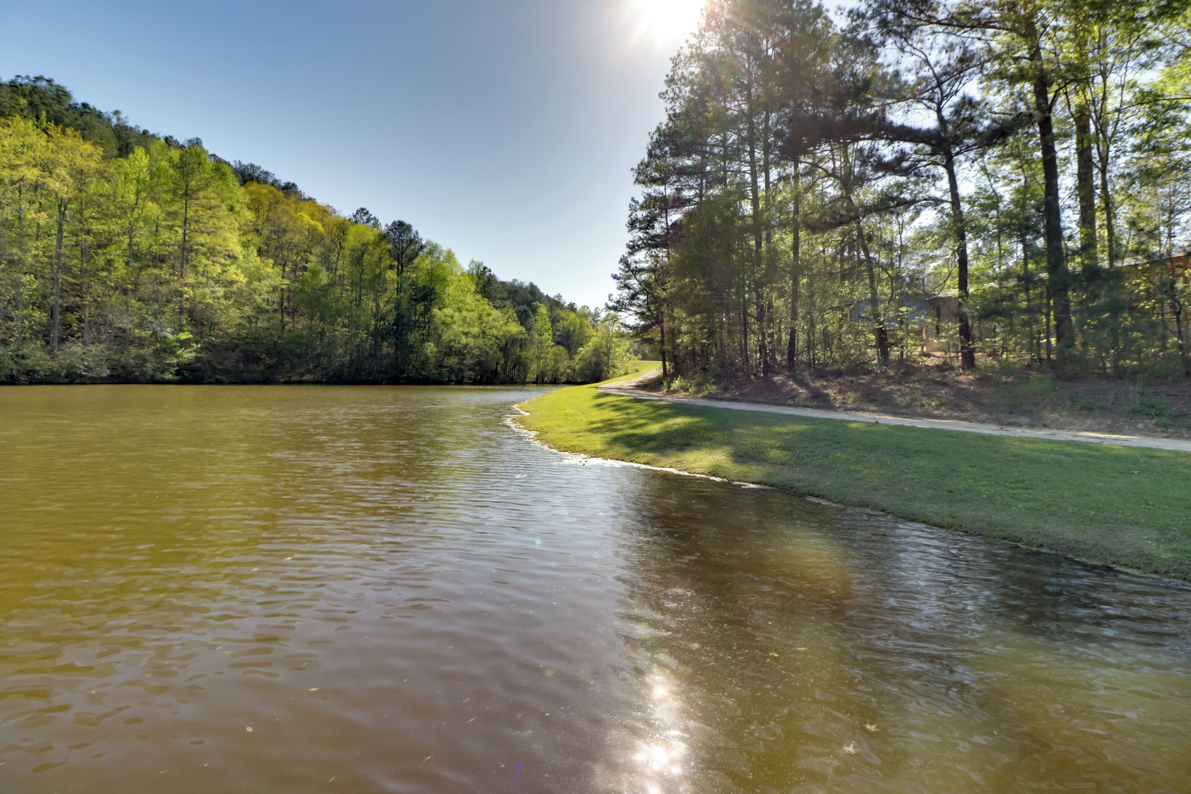 A river with a grassy bank and trees on one side.