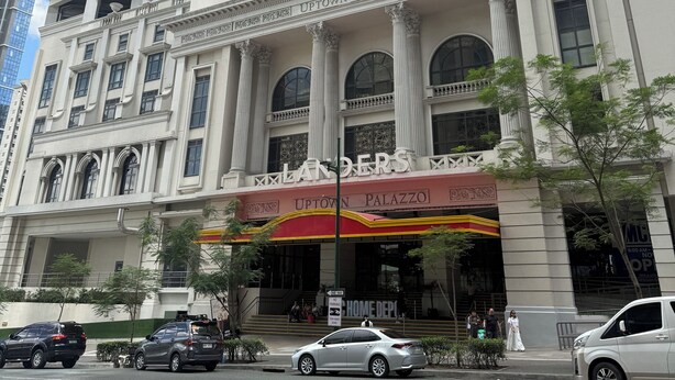A historic building with a classical facade, a prominent entrance, and a sign reading "Landers Uptown Palazzo." - Your Perfect Home Base — Comfort and Convenience! (Taguig)