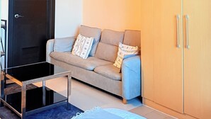 A modern room with a sofa, a bed, a wardrobe, and a painting on the wall. - Your Perfect Home Base — Comfort and Convenience! (Taguig)