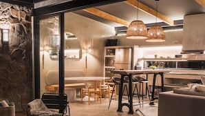 Una cocina moderna con comedor, que cuenta con piso de madera, una barra y un área de descanso.