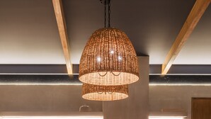Una cocina moderna con una isla central, iluminación colgante y una zona de comedor con taburetes de bar.