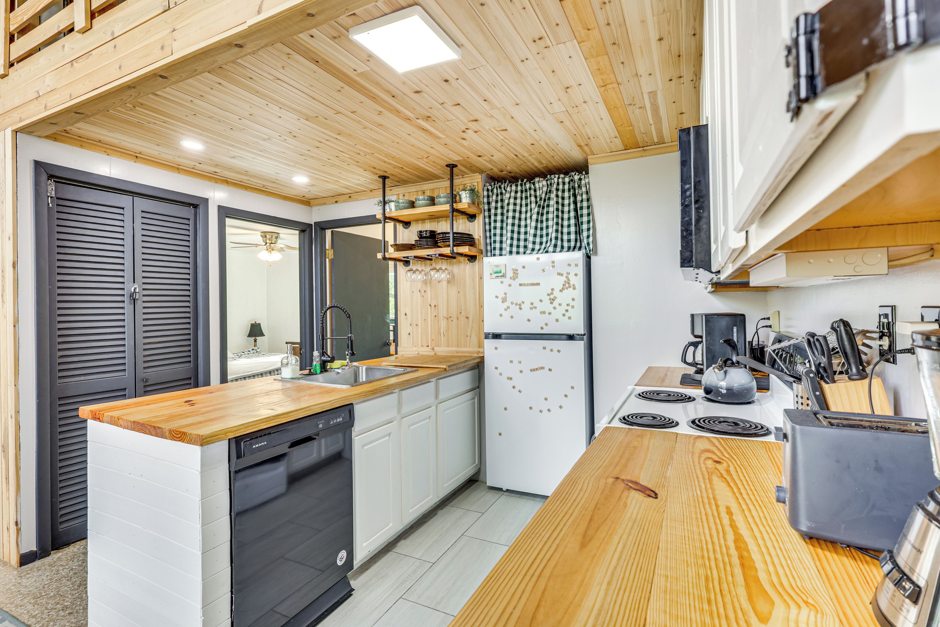 A modern kitchen with wooden countertops, a dishwasher, a refrigerator, and a coffee maker.