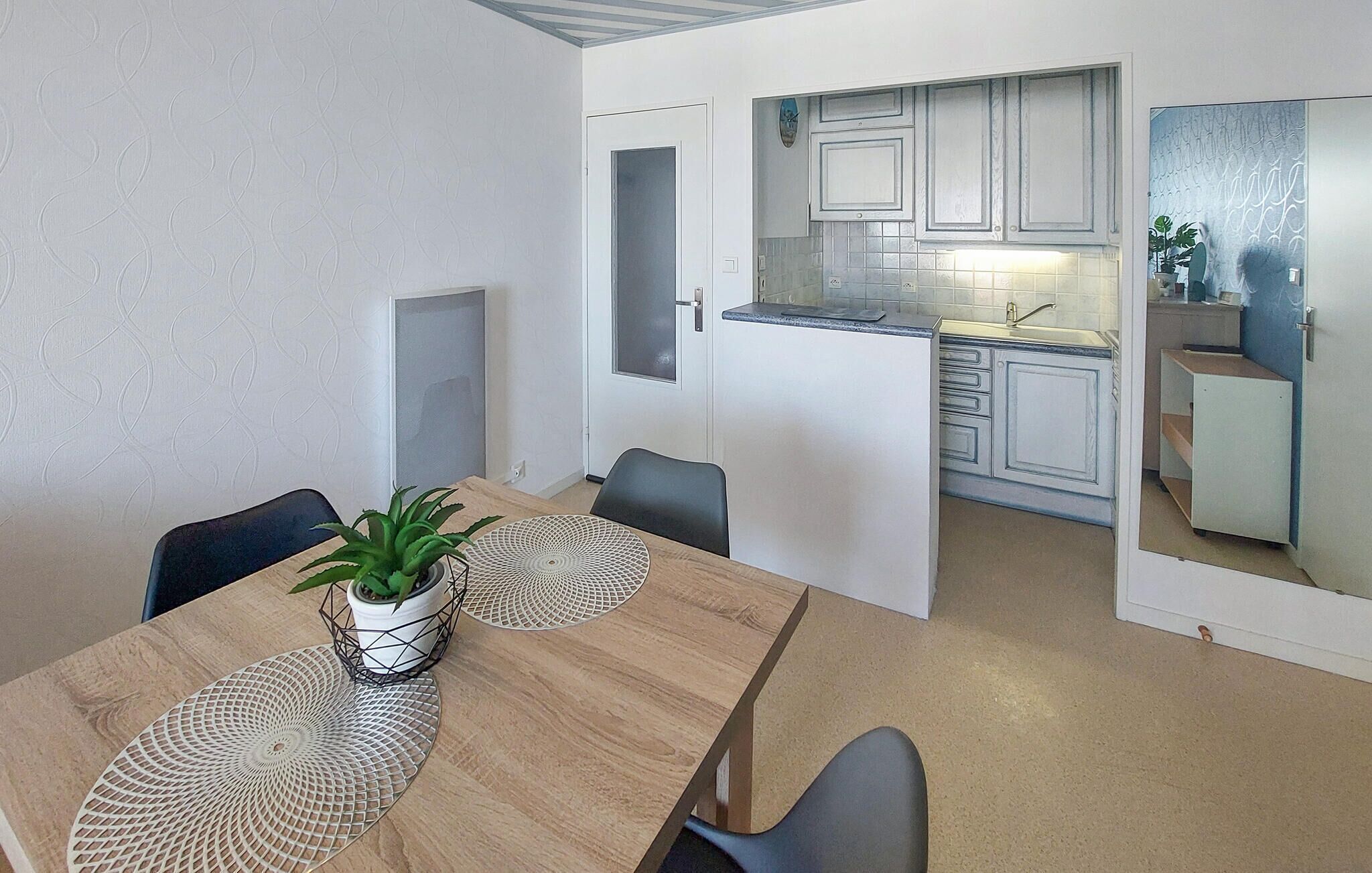 Um espaço de estar compacto com área de refeições e cozinha compacta.