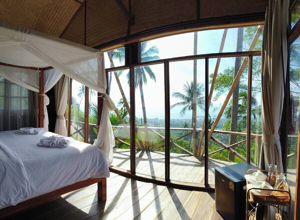 A room with a bed, a window with a view of palm trees, and a small table with a tray. - RoomQuest THEVA Resort koh Samui (Koh Samui)