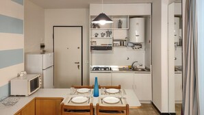 A compact kitchen with a dining area, a microwave, a stove, and a sink. - 2 bedroom lovely apartment in Lavagna (Lavagna)