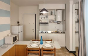 A compact kitchen with a dining area, a microwave, a stove, and a sink. - 2 bedroom lovely apartment in Lavagna (Lavagna)