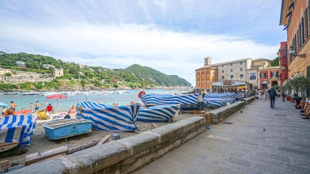 A coastal town with boats covered with striped tarps, a stone wall, and buildings along the waterfront. - 2 bedroom lovely apartment in Lavagna (Lavagna)