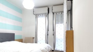A bedroom with a bed, a radiator, curtains, and a wardrobe. - 2 bedroom lovely apartment in Lavagna (Lavagna)