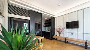 A modern kitchen with a built-in microwave, a wooden dining table with chairs, and a bench along the wall. - free pool the manor luxury condotel (Ho Chi Minh City)
