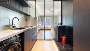 A modern kitchen with a washing machine, a sink, and a fire extinguisher. - free pool the manor luxury condotel (Ho Chi Minh City)