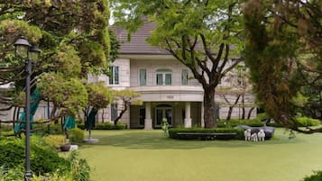 A large, two-story building with a formal entrance and a well-maintained garden.