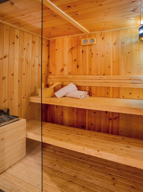 A wooden sauna with benches and a bench with towels. - Hotel Sercotel Plana Onda (Onda)