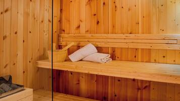 A wooden sauna with benches and a bench seat, a wooden wall, and a wooden floor.