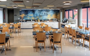 A spacious cafeteria with multiple tables and chairs, a coffee station, and a large abstract mural on the back wall. - Hotel Sercotel Plana Onda (Onda)