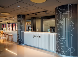 A hotel reception area with a modern design, featuring a reception desk, seating area, and a large window with a view. - Hotel Sercotel Plana Onda (Onda)