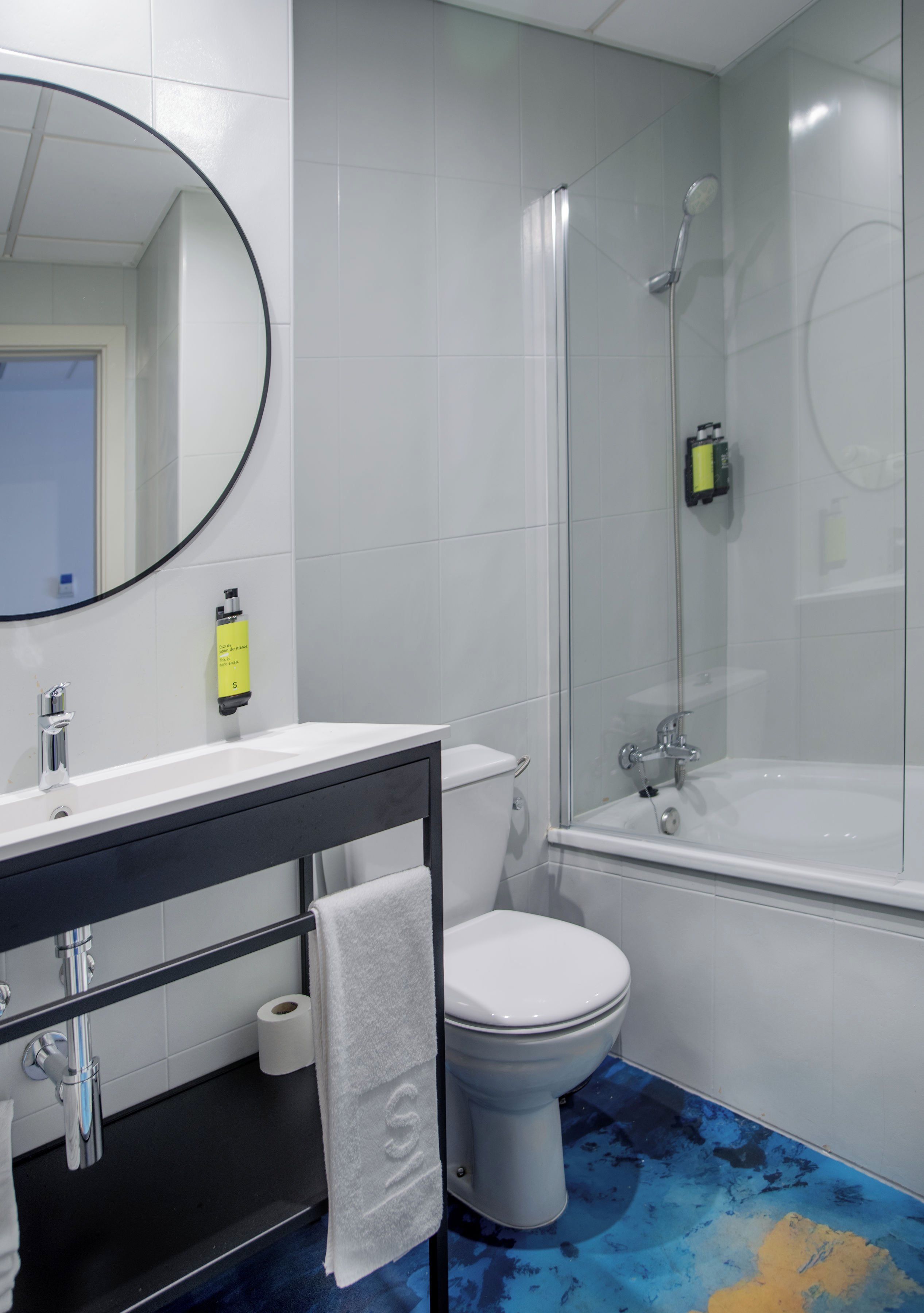 Un baño con inodoro, lavamanos y ducha.