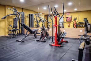 A gym with various exercise equipment, including a rowing machine, a leg press, and a stationary bike. - Hotel Sercotel Plana Onda (Onda)