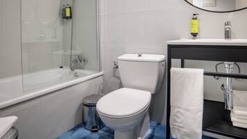Un baño con bañera, inodoro y lavamanos.