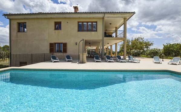 Un bâtiment à deux étages doté d’une piscine, d’un espace extérieur aménagé et d’un patio couvert.