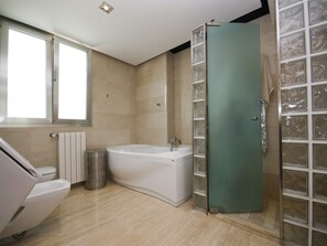 Ein modernes Badezimmer mit Badewanne, Duschkabine und Toilette.