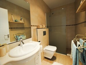 A bathroom with a sink, toilet, and shower.