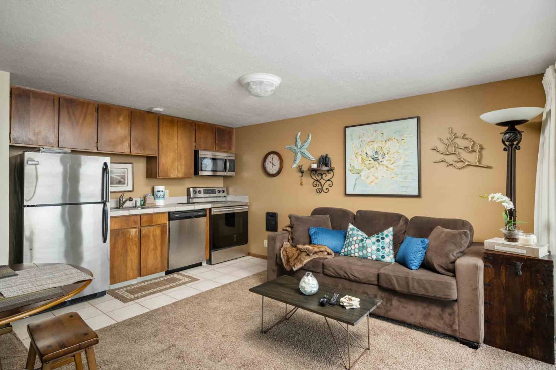 A compact living space with a kitchenette, a sofa set, and a coffee table.