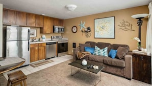 A compact living space with a kitchenette, a sofa set, and a coffee table. - Ultimate Oceanfront Escape for Two at Beachy Eagle B, Amazing Views, Fire-Table, Steps from Beach (Rockaway Beach)