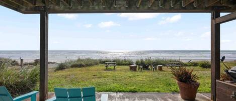 A covered outdoor seating area with a view of the ocean.