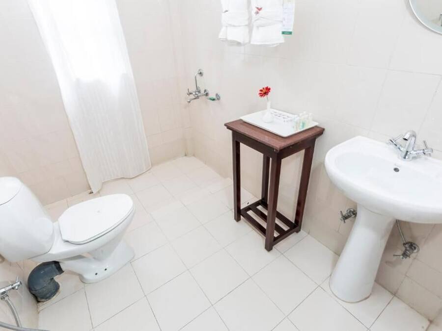 Un baño pequeño con inodoro, lavamanos y ducha.