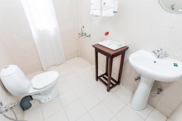 A small bathroom with a toilet, a sink, and a shower. - NOUNE RESORT (Dimapur)