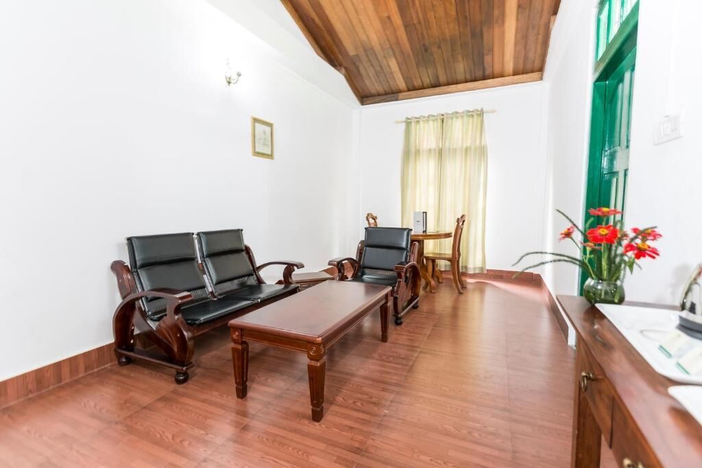 Una habitación con techo de madera, un conjunto de sofás, una mesa de comedor y una pequeña cocina.