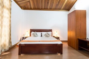 Cozy retreat with a comfortable bed, nightstand, and wardrobe.