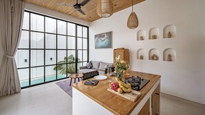 Een moderne woonkamer met een groot raam, een houten plafond en een eethoek met een houten tafel.