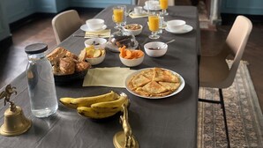A dining table set with breakfast items, including pastries, fruit, and a bottle of water. - Bed and breakfast in a small chateau in the Loire Valley (Saint-Cyr-en-Pail)