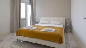 Ein modernes Schlafzimmer mit Bett, Fenster und Nachttischlampe.