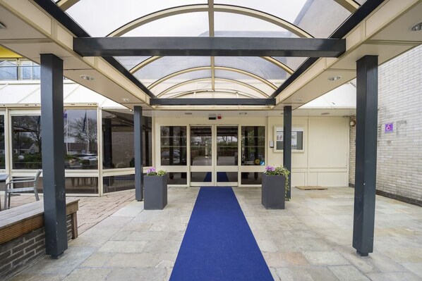 Enter a welcoming space with a clear view into the interior, guided by a blue carpet and surrounded by natural light.