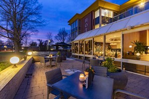 Relax in the hotel's serene patio, surrounded by lush trees and the hotel building in the background.