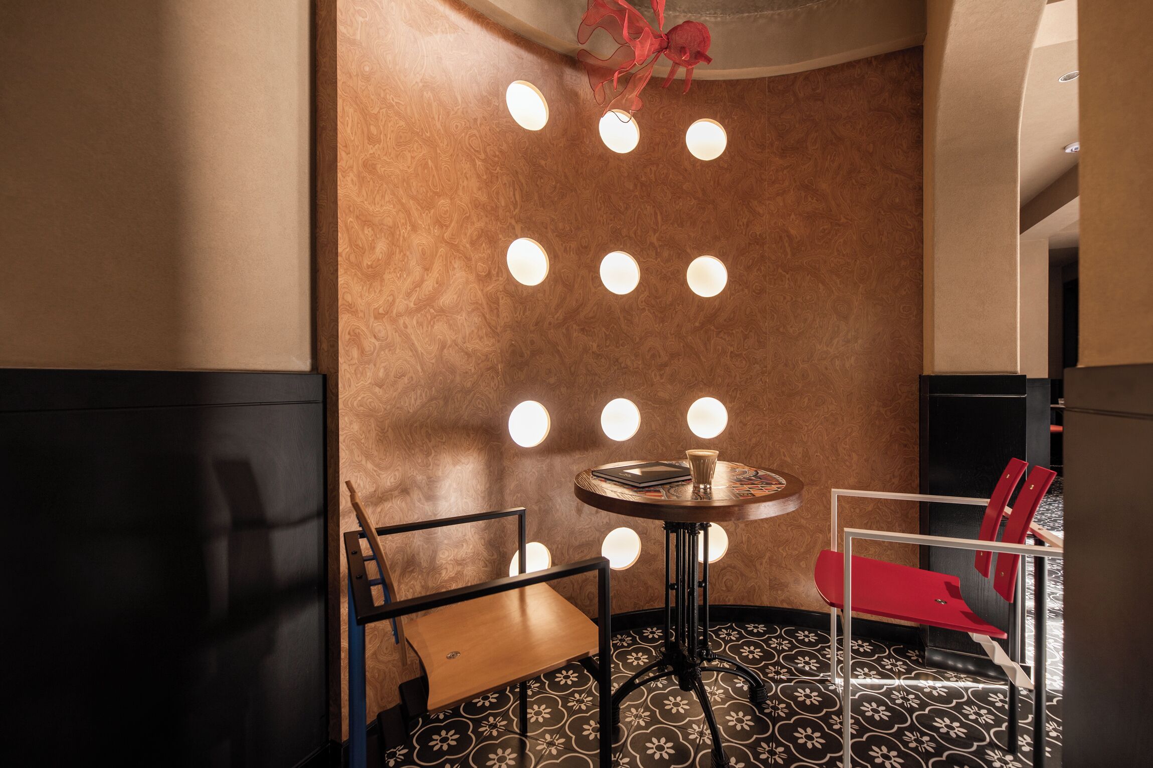 A modern interior with a round table, two chairs, and a patterned floor.